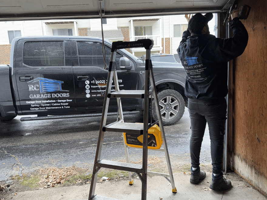 Technician working inside a garage during a garage door service call.