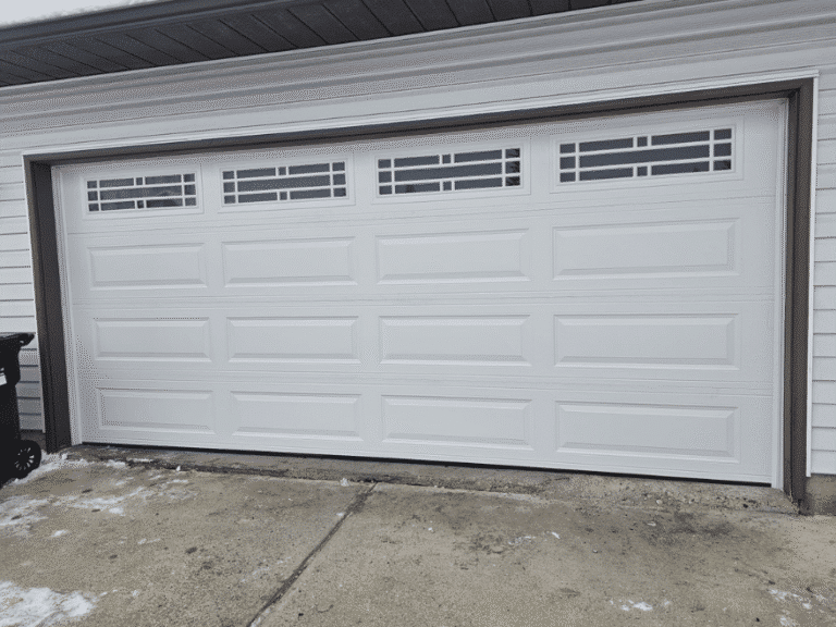 White double garage door with raised panels and decorative top windows.