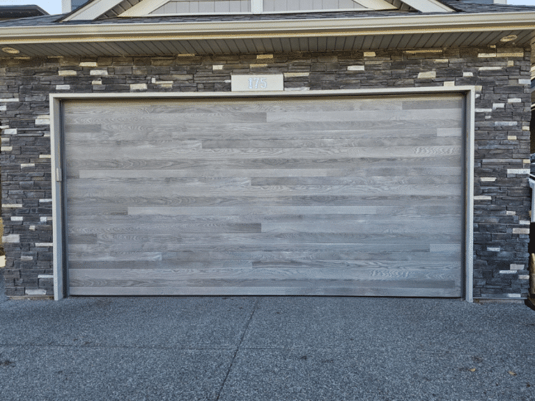 Gray double garage door with a horizontal wood-look finish.