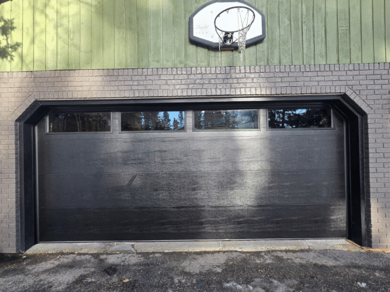 Black flush garage door with a row of upper windows.