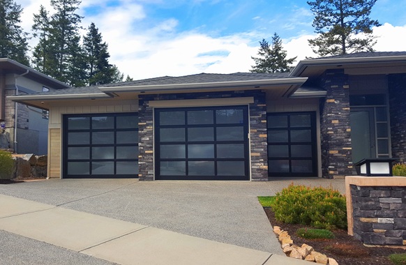 Modern home with three black full-view glass garage doors.